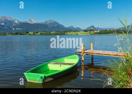 Canottaggio in un molo, lago Hopfensee, Hopfen am See, Alpi Allgau, Allgau, Schwaben, Baviera, Germania, Europa Foto Stock