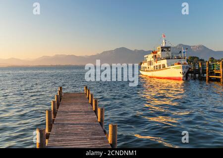 Escursione in barca su un molo all'alba, Gstadt am Chiemsee, Lago Chiemsee, alta Baviera, Germania, Europa Foto Stock