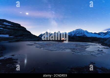 Tenda sotto cielo stellato e Via Lattea con Monte Disgrazia sullo sfondo, Alpe Fora, Valmalenco, provincia di Sondrio, Lombardia, Italia, Europa Foto Stock