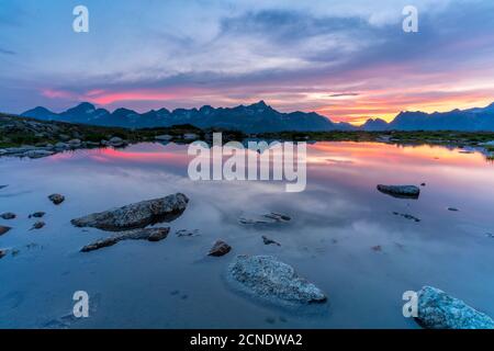 Cielo ardente al tramonto sulle montagne che si specchiano nel lago incontaminato, Muottas Muragl, Engadina, cantone di Graubunden, Svizzera, Europa Foto Stock