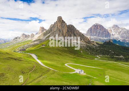 Strada tortuosa del Passo Giau nel verde con i monti Ra Gusela e Tofane sullo sfondo, Dolomiti, Veneto, Italia, Europa Foto Stock