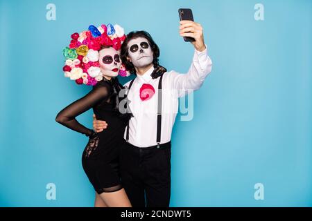 Foto di mostro spettrale coppia uomo donna abbraccio tenere telefono fare tema selfie immagine indossare breve mini nero abito morte fascia costume roses Foto Stock