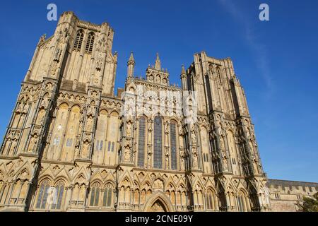 La storica facciata occidentale della Cattedrale di Wells, con le sue torri quadrate gemelle, a Wells, Somerset, Inghilterra, Regno Unito, Europa Foto Stock