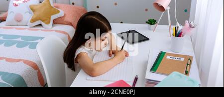 Ragazza che fa i compiti nella sua camera da letto Foto Stock