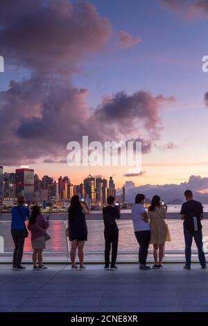 La gente guarda il tramonto da Harbour City, Hong Kong, Cina, Asia Foto Stock