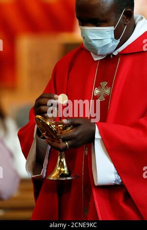 Epidemia di coronavirus (Covid-19), Celebrazione della Messa di Pentecoste dopo il blocco, Santa comunione, Chiesa di San Luigi di romanzo Foto Stock