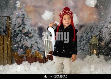 Ragazzo carino, bambino prescolare, giocare nella neve all'aperto, studio shot Foto Stock