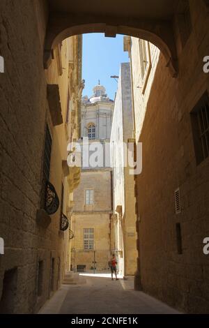 Turista femminile in una stretta strada posteriore nel medievale Città fortificata di Mdina a Malta Foto Stock