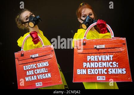 I manifestanti con rivestimento HAZMAT del gruppo PETA Animal Rights dimostrano fuori della Somerset House, il luogo della London Fashion Week. Foto Stock