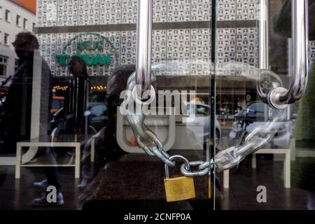 Hannover, Germania. 28 Agosto 2020. Una catena con lucchetto pende sulla porta di vetro di un negozio chiuso nel centro storico, la porta riflette il ramo di GALERIA Karstadt Kaufhof al Marktkirche. Sempre più negozi stanno chiudendo, le città interne sono desolanti - anche a causa di Corona. Credit: Stefan Jaitner/dpa/Alamy Live News Foto Stock