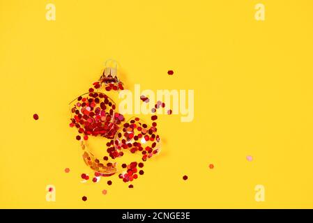 Rotto palla ornamento albero di Natale su sfondo giallo. Rotto vecchie decorazioni xmas Foto Stock