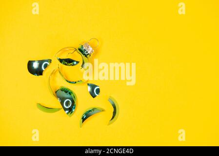 Rotto palla ornamento albero di Natale su sfondo giallo. Rotto vecchie decorazioni xmas Foto Stock