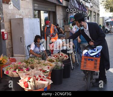 Gerusalemme, Israele. 18 Settembre 2020. Un ebreo ultra-ortodosso acquista fiori per Rosh Hashanah, il nuovo anno ebraico, nel mercato Mahane Yehuda di Gerusalemme, venerdì 18 settembre 2020. Israele entra in un blocco nazionale di tre settimane prima dell'inizio di Rosh Hashanah nel tentativo del governo di ridurre la diffusione dilagante di COVID-19, costringendo i residenti a rimanere a casa durante le alte vacanze ebraiche. Foto di Debbie Hill/UPI Credit: UPI/Alamy Live News Foto Stock