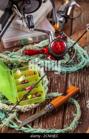Diverse tegole da pesca con verga e bobine su sfondo marrone di legno. Mockap per la pubblicità e la pubblicazione. Foto Stock