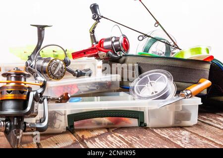 Diverse tegole da pesca con verga e bobine su sfondo marrone di legno. Mockap per la pubblicità e la pubblicazione. Foto Stock