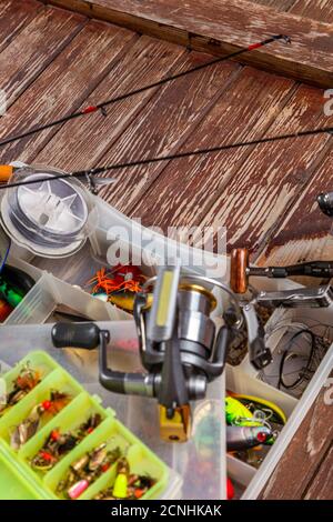 Diverse tegole da pesca con verga e bobine su sfondo marrone di legno. Mockap per la pubblicità e la pubblicazione. Foto Stock