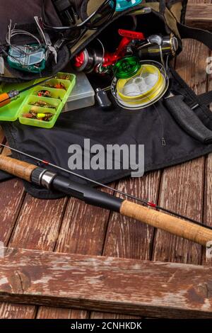 Diverse tegole da pesca con verga e bobine su sfondo marrone di legno. Mockap per la pubblicità e la pubblicazione. Foto Stock