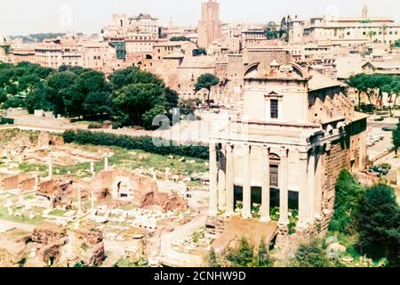 Tempio di Antonino e Faustina nel Foro Romano, sullo sfondo della città di Roma, 1986 aprile Foto Stock