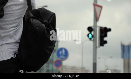 Giovane uomo che cammina su uno zaino verde e una borsa. Foto Stock