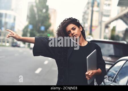 Grave razza mista donna utilizzare un telefono, provare a prendere un taxi. Immagine filtrata Foto Stock