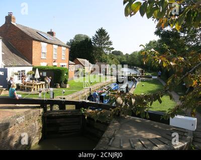 Pomeriggio soleggiato d'autunno sul Canal Grande Union nel Northamptonshire con due barche strette che si trovano tra i cancelli vicino al pub di Braunston. Foto Stock