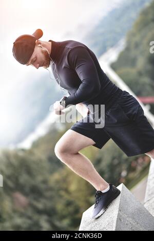 Close-up shot barbuto uomo sportive dopo la sessione di allenamento fitness verifiche dei risultati. Adulto ragazzo indossa Sport Tracker braccialetto. Foto Stock