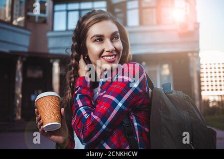 Bellissima ragazza camminare sulla strada con il caffè. Foto Stock