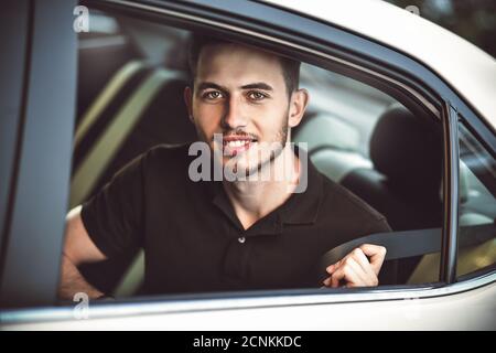 Passeggero uomo allacciando la cintura di sicurezza nella vettura, concetto di sicurezza. Foto Stock