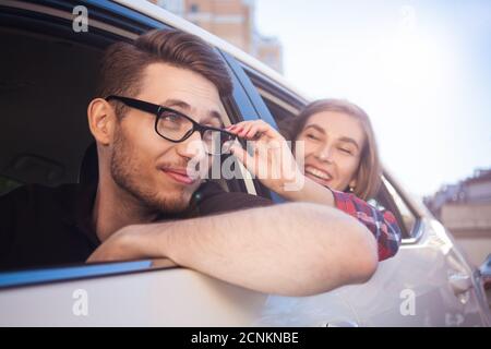 Giovane coppia caucasica in auto che si diverte in viaggio su strada Foto Stock