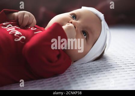 Bambina piccola giace sul letto, tema di natale. Foto Stock