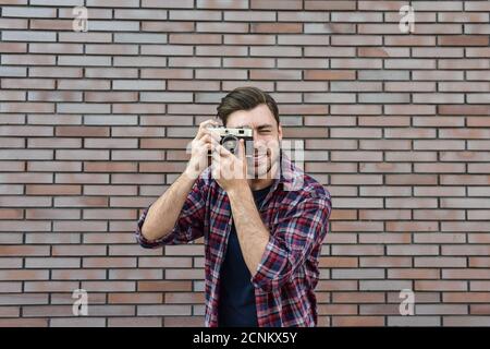 Dite formaggio, hipster fotografo di moda uomo con fotocamera retrò Foto Stock