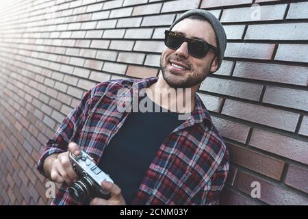 Dite formaggio, hipster fotografo di moda uomo con fotocamera retrò Foto Stock