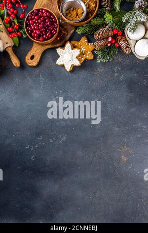 Ingredienti per la cucina di Natale, biscotti da forno invernali, pan di zenzero, torta di frutta, bevande di stagione. Mirtilli rossi, arance secche, cannella, spezie, farina Foto Stock