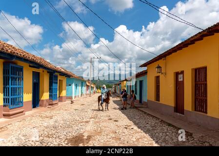 24 agosto 2019: Uomo equitazione nelle strade colorate di Trinidad. Trinidad, Cuba Foto Stock