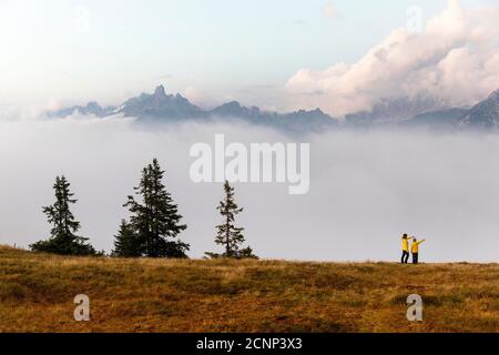 Madre e figlio in piedi sulla montagna Rossbrand guardando picchi in piedi dalla nebbia Foto Stock
