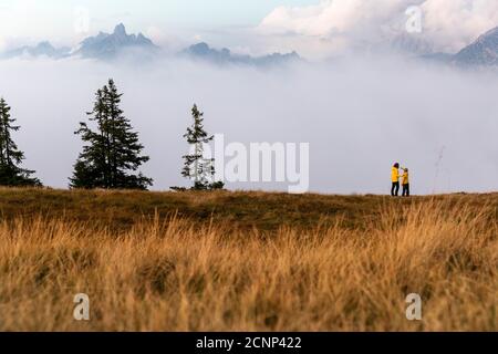 Madre e figlio in piedi sulla montagna Rossbrand guardando picchi in piedi dalla nebbia Foto Stock
