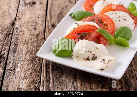 Insalata tradizionale di caprese con pomodoro e mozzarella su legno tabella Foto Stock