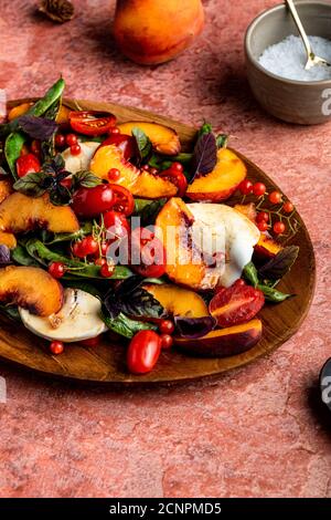 Vivace insalata caprese di stagione con succosa frutta di pietra. Foto Stock