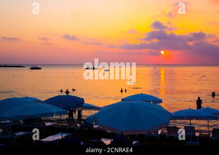 Bellissimo tramonto arancione-viola sulla spiaggia del mare Foto Stock