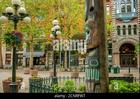 Un totem con il Pioneer Building sullo sfondo di Pioneer Square a Seattle, nello stato di Washington, USA. Foto Stock