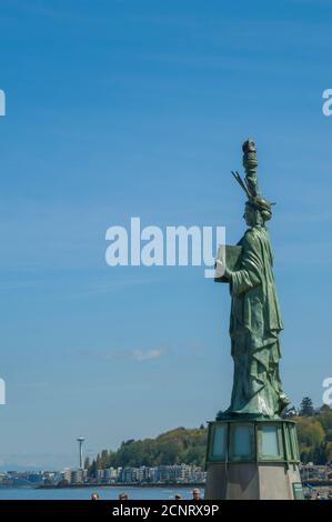 Una replica della Statua della libertà con lo Space Needle sullo sfondo sulla spiaggia di Alki Beach a West Seattle, Washington state, USA. Foto Stock