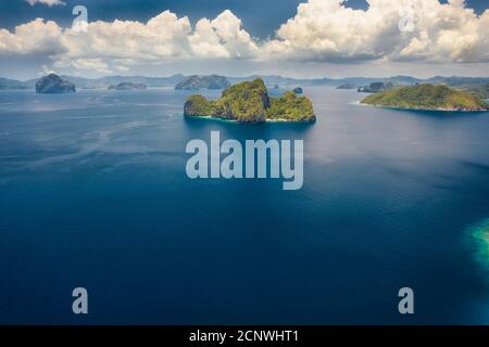 Vista aerea dell'isola di Entalula da lontano. Oceano aperto, nuvole bianche ad alta quota. Bacuit Bay, El Nido, Palawan, Filippine. Foto Stock