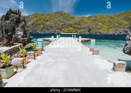 El Nido, Palawan, Filippine. Molo di attracco sull'isola di MatBloc con l'isola tropicale sullo sfondo. Foto Stock