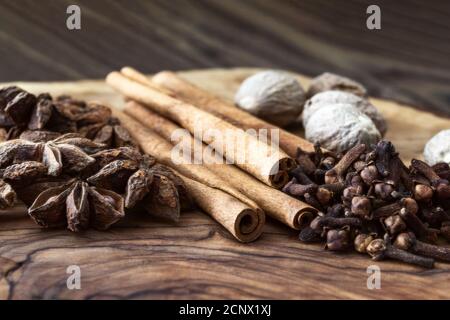spezie intere, noce moscata aromatica, bastoncini di cannella, chiodi di garofano, piano portapaziente con anice stellato, still life Foto Stock