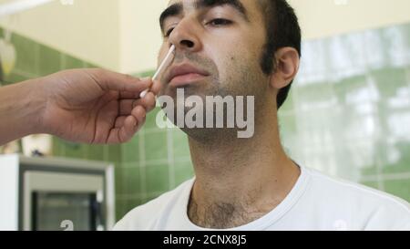 Analisi uomo con tampone per coronavirus in laboratorio Foto Stock