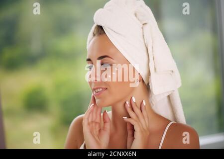 bellezza e spa. Trattamento viso. Cosmetology ragazza con pelle pulita fresca che tocca il suo viso Foto Stock