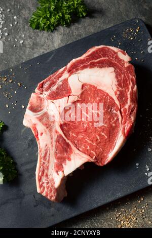 Grass crudo alimentato Ribeye Steak con sale e pepe Foto Stock