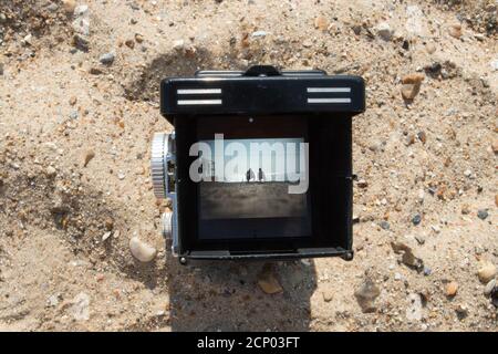 Una fotocamera reflex doppia Rolleiflex vintage che incornicia un soggetto una scena da spiaggia nel mirino Foto Stock