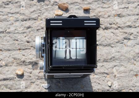 Una fotocamera reflex doppia Rolleiflex vintage che incornicia un soggetto una scena da spiaggia nel mirino Foto Stock