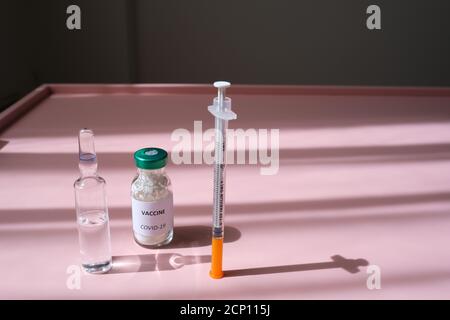 Covid 19 virus, concetto sanitario con la mano blu medico guanto che tiene una fiala di vaccino per il trattamento del virus Foto Stock